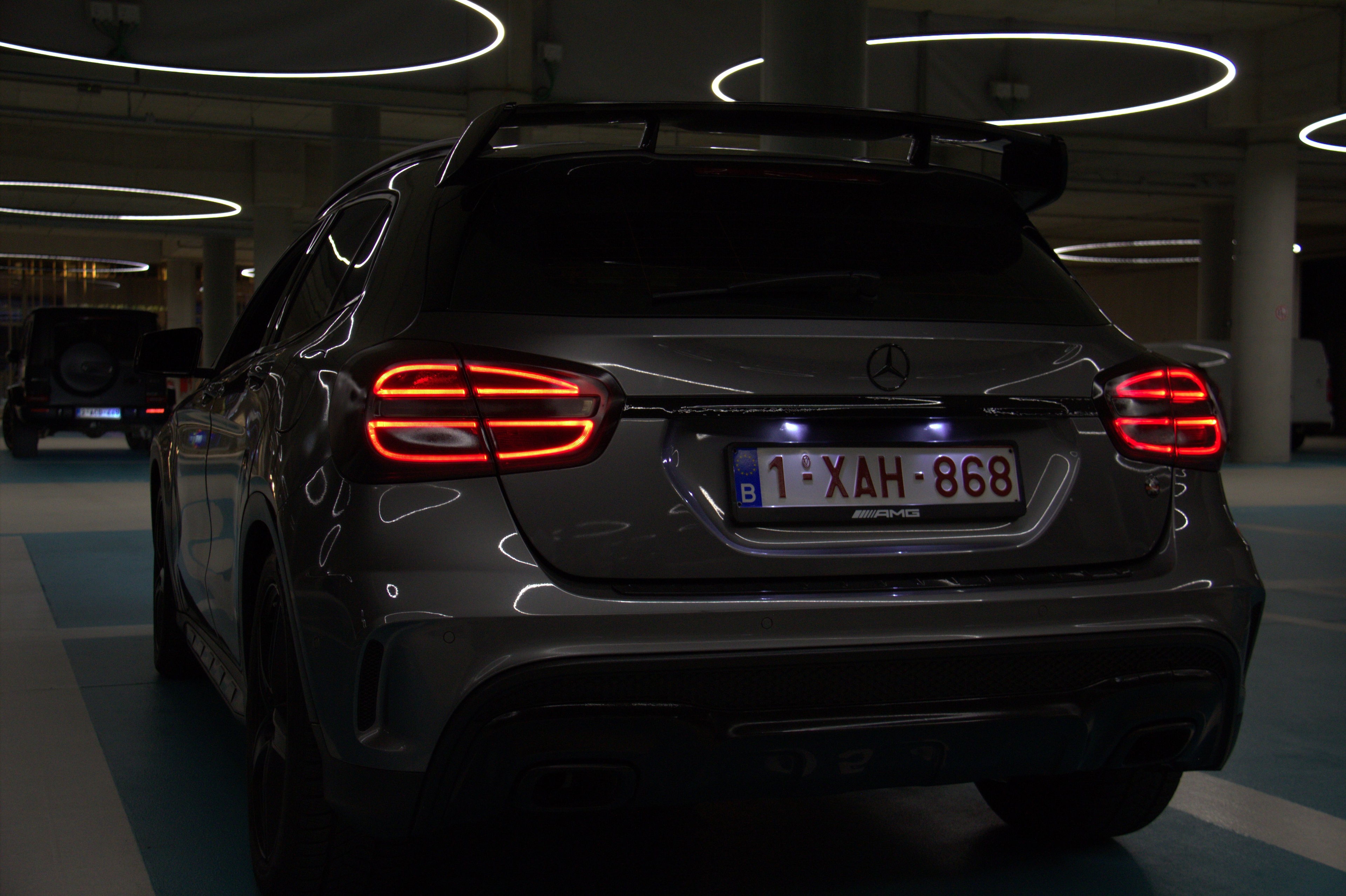 Achteraanzicht van een Mercedes-AMG SUV met verlichte achterlichten, geparkeerd in een ondergrondse garage.